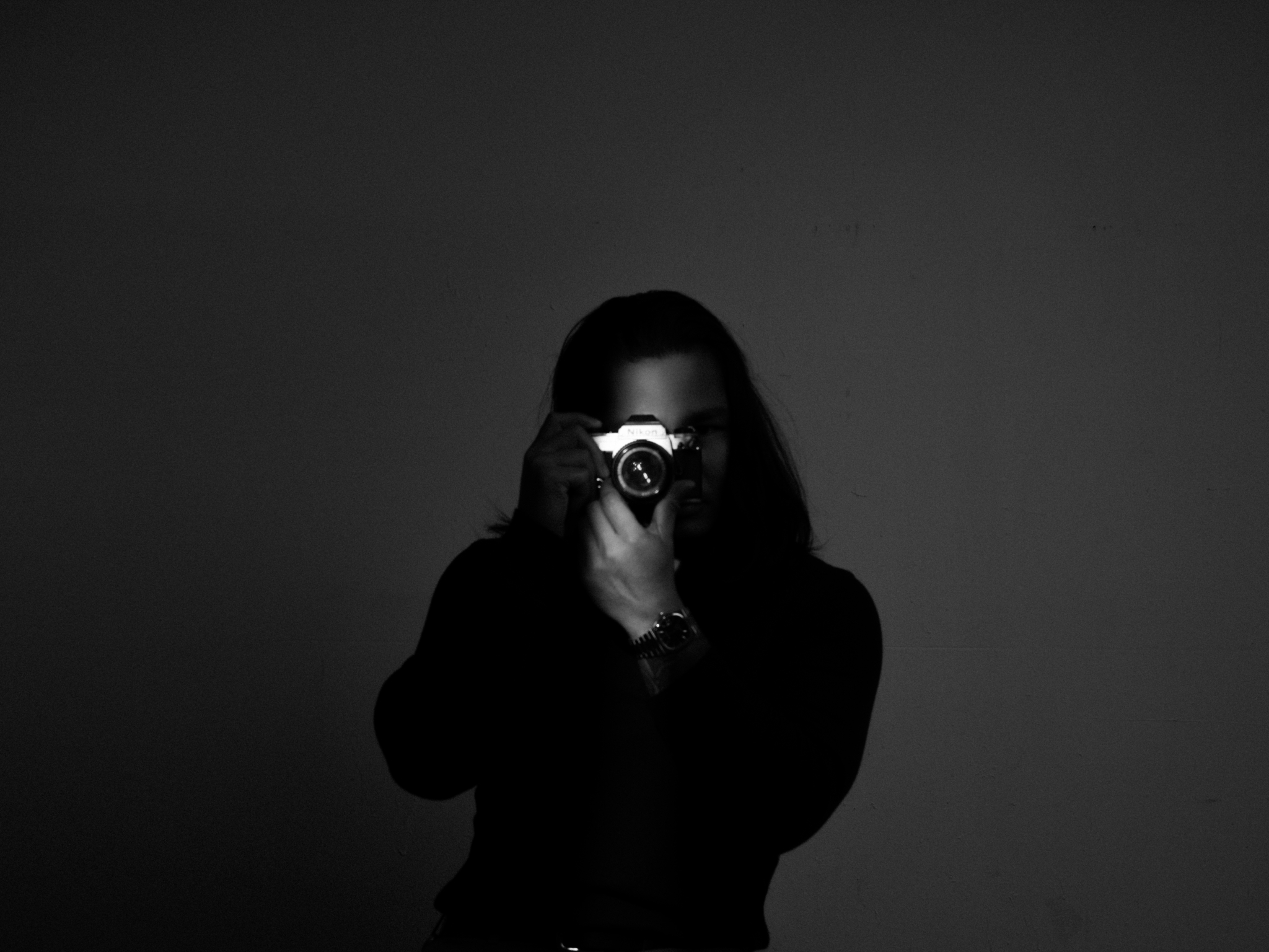 Khai Nguyen holding a Fuji camera up to his eye